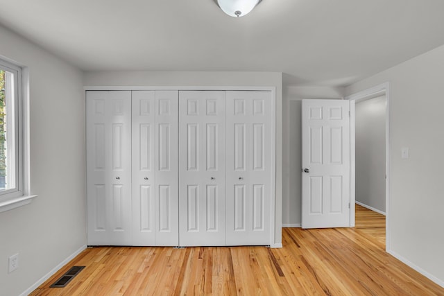 unfurnished bedroom featuring a closet and light hardwood / wood-style floors