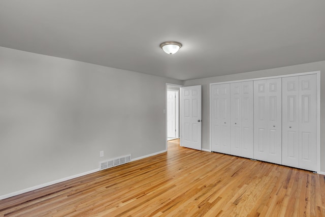 unfurnished bedroom featuring a closet and light wood-type flooring