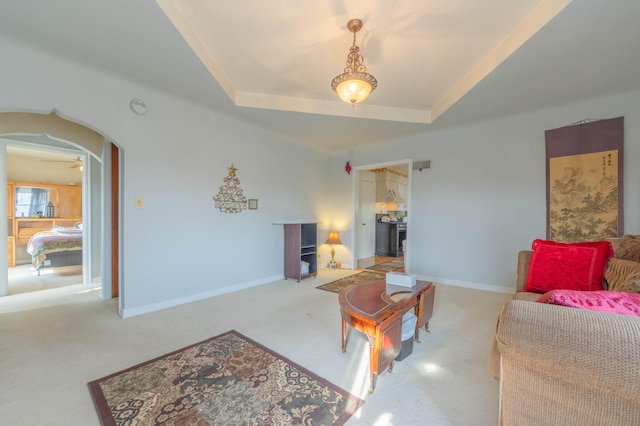 carpeted living room with a tray ceiling