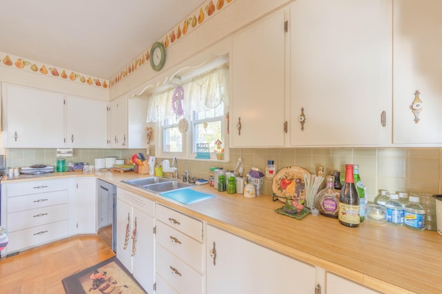 kitchen featuring backsplash, white cabinetry, sink, and light parquet flooring