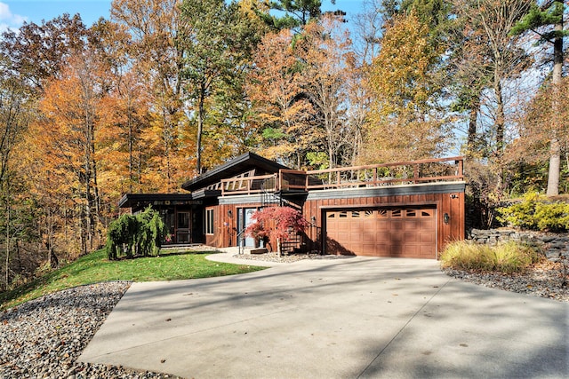 view of front of home with concrete driveway, a front lawn, and an attached garage