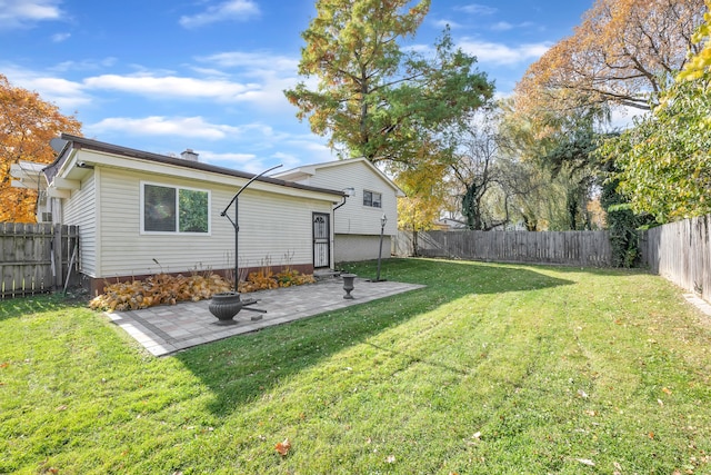 back of house with a yard and a patio