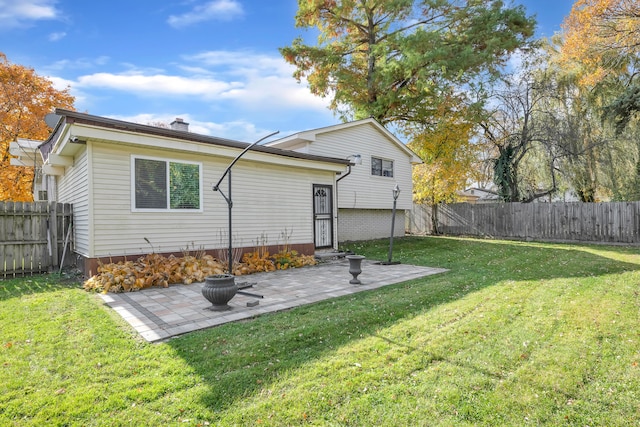 rear view of house featuring a patio area and a yard