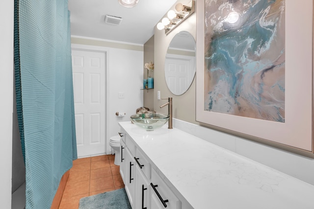 bathroom featuring tile patterned floors, crown molding, vanity, and toilet