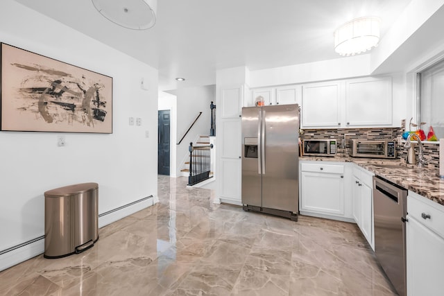 kitchen featuring tasteful backsplash, stainless steel appliances, a baseboard heating unit, stone counters, and white cabinetry