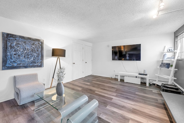 living room with wood-type flooring and a textured ceiling