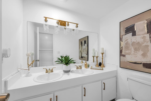 bathroom with vanity, toilet, and tile walls