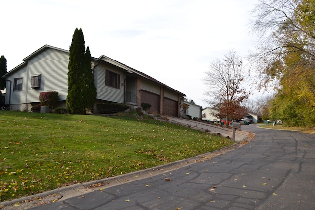 view of property exterior featuring a lawn and a garage