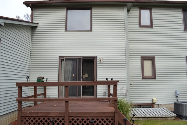 rear view of house with central AC unit and a wooden deck