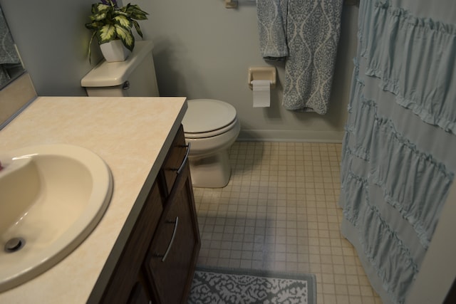 bathroom featuring toilet, vanity, and a shower with curtain