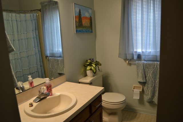 bathroom featuring toilet, curtained shower, and vanity