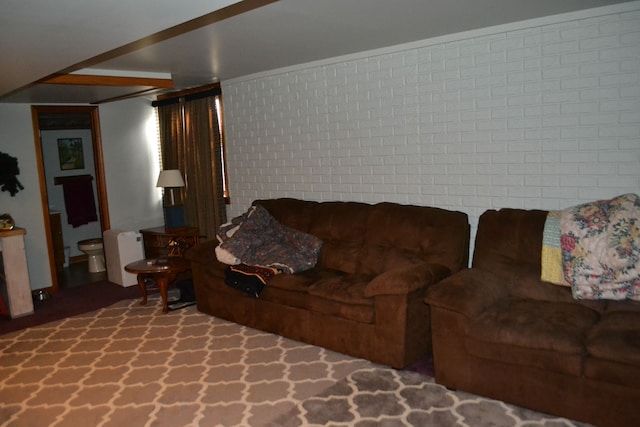 living room featuring carpet and brick wall