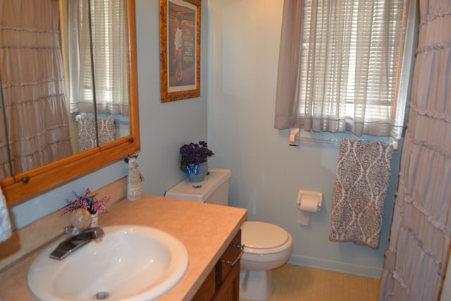 bathroom featuring toilet, tile patterned flooring, and vanity