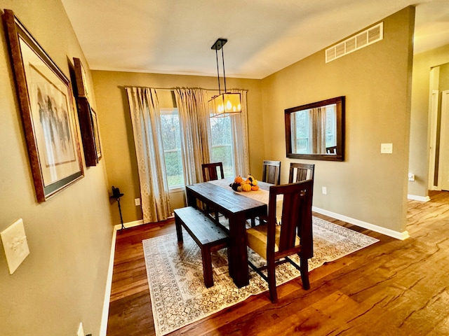 dining area featuring hardwood / wood-style floors and a chandelier