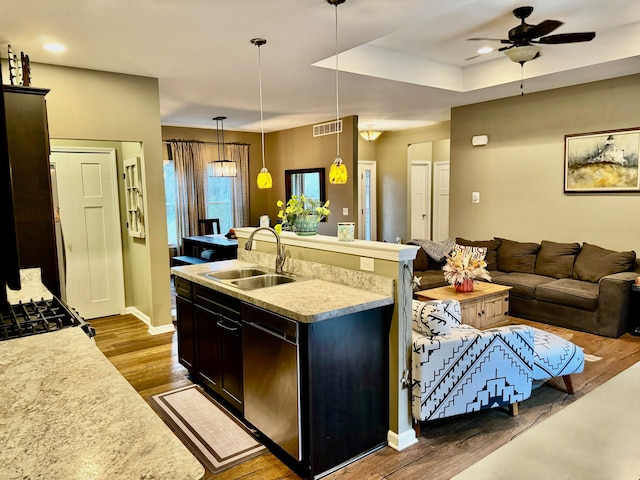 kitchen with dishwasher, sink, dark hardwood / wood-style floors, an island with sink, and decorative light fixtures