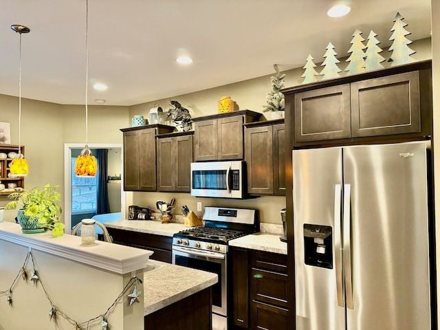 kitchen with dark brown cabinetry, decorative light fixtures, and appliances with stainless steel finishes