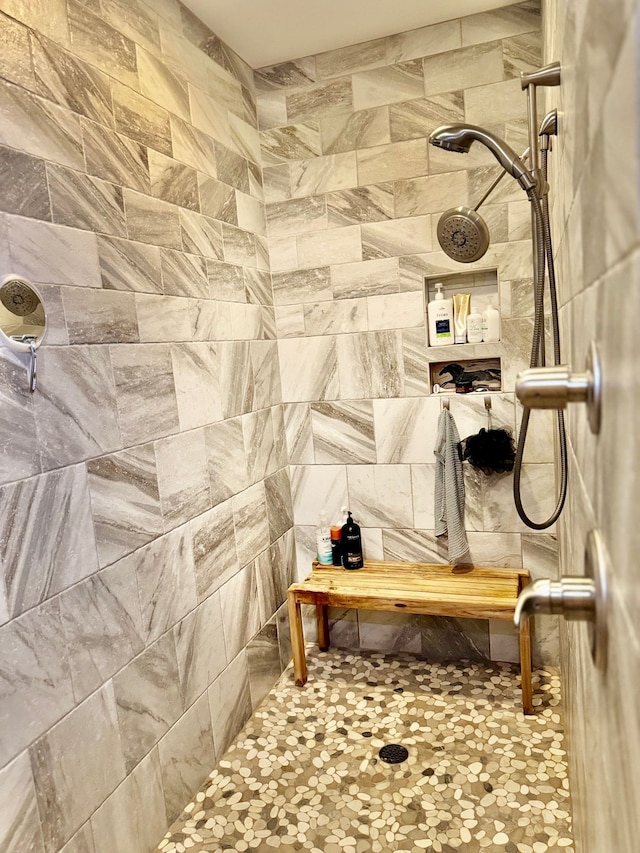 bathroom featuring a tile shower and tile walls