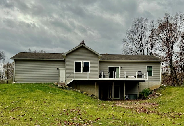 back of house featuring a lawn and a deck