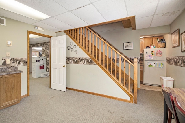 stairs with carpet and a drop ceiling