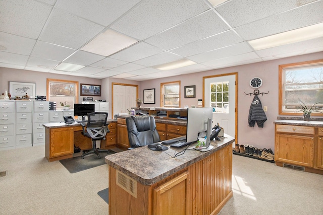 office space with a drop ceiling and light colored carpet