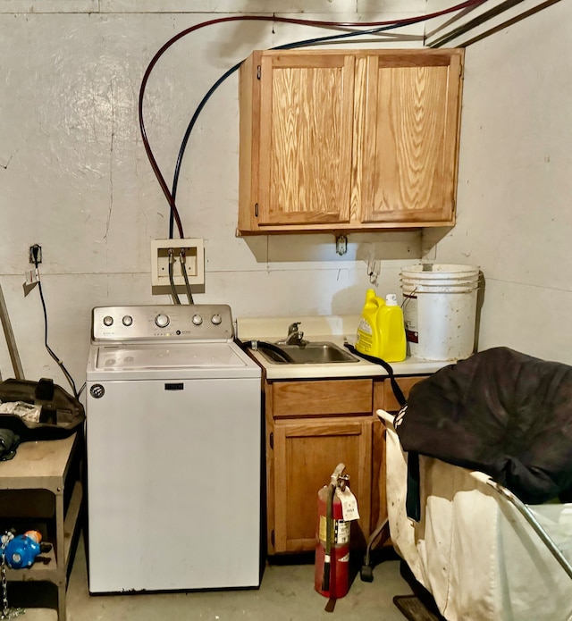 clothes washing area with cabinets, sink, and washer / clothes dryer