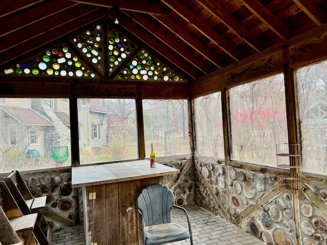 sunroom with vaulted ceiling with beams