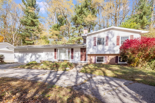 tri-level home featuring a garage and a front yard