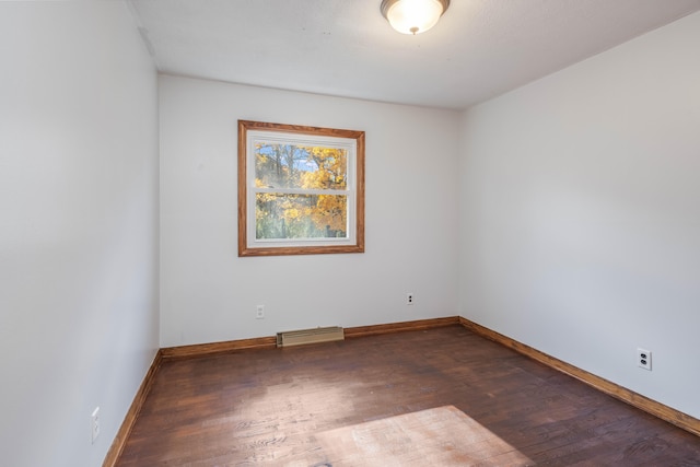 spare room featuring dark hardwood / wood-style floors and baseboard heating