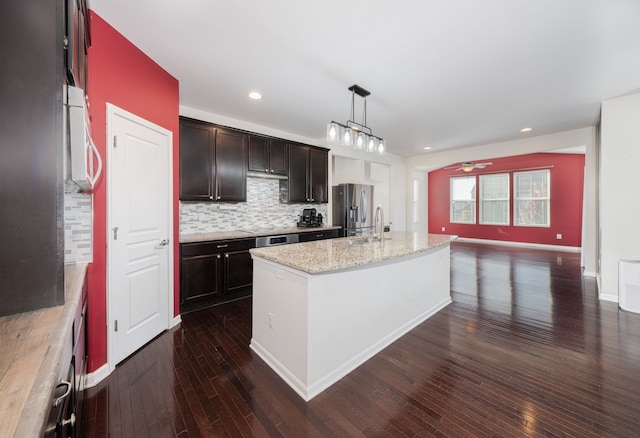 kitchen featuring a center island with sink, dark hardwood / wood-style floors, ceiling fan, and hanging light fixtures