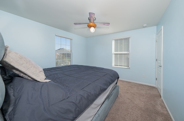 bedroom with ceiling fan and light carpet