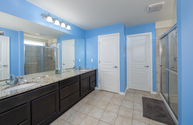 bathroom with tile patterned floors, vanity, and a shower with door