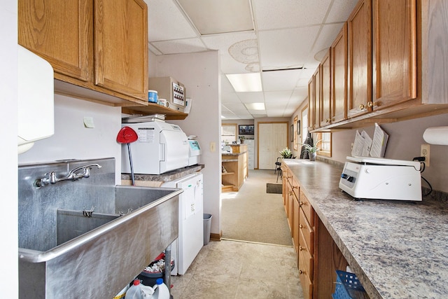 kitchen featuring a drop ceiling and sink