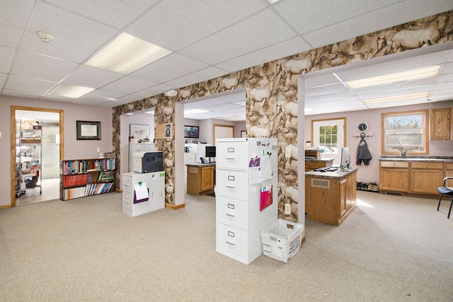 carpeted home office with a drop ceiling