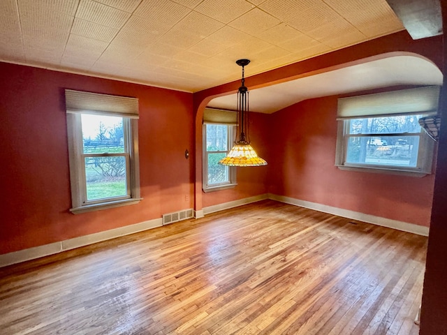 unfurnished dining area with lofted ceiling and hardwood / wood-style flooring