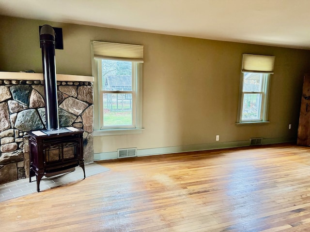 interior space with light hardwood / wood-style flooring and a wood stove