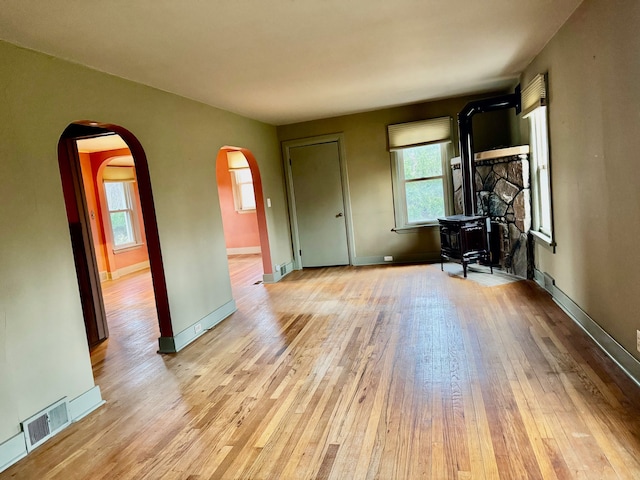 interior space with a wood stove and light hardwood / wood-style flooring