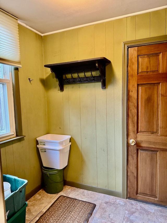 bathroom with tile patterned floors and wood walls