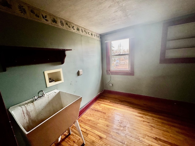 washroom featuring hookup for a washing machine, a textured ceiling, hardwood / wood-style flooring, and sink