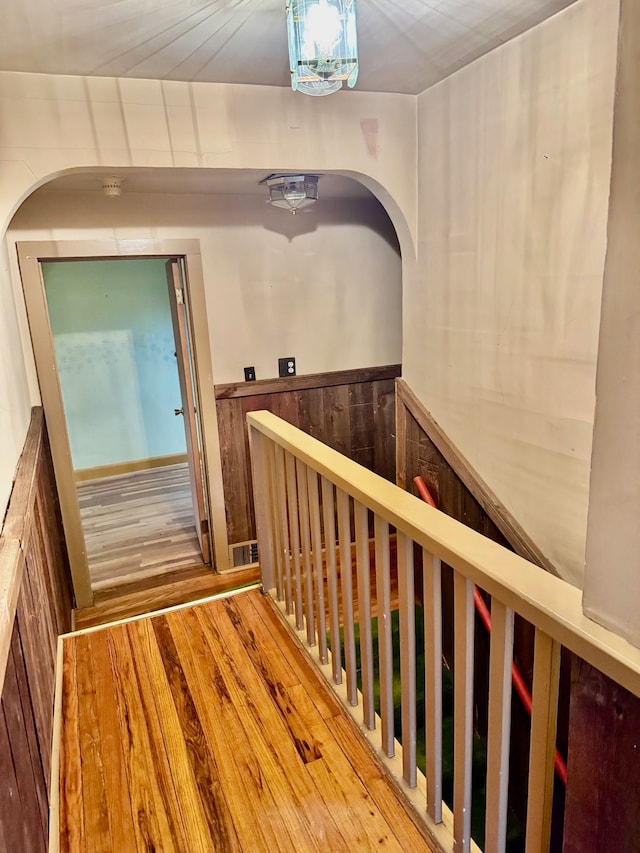 hall featuring hardwood / wood-style floors and wooden walls