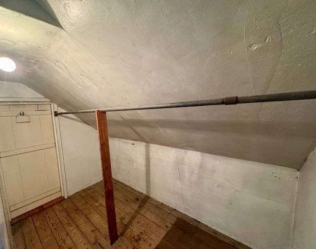 bonus room with wood-type flooring and vaulted ceiling