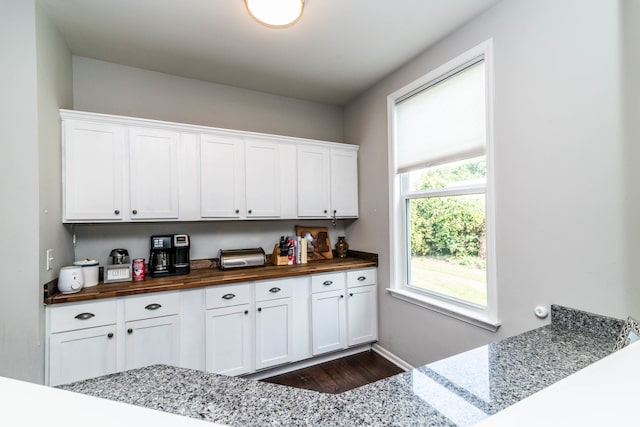 kitchen featuring dark wood-type flooring, white cabinets, and wood counters