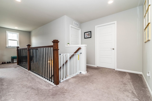 hall featuring light colored carpet