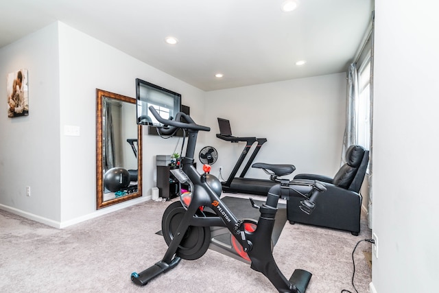 workout room featuring light carpet