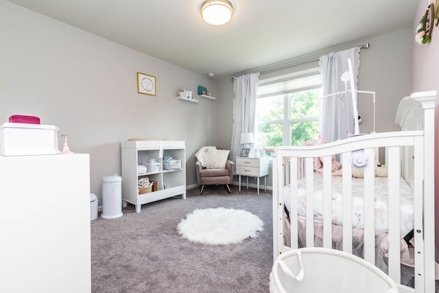 bedroom featuring a crib and dark carpet