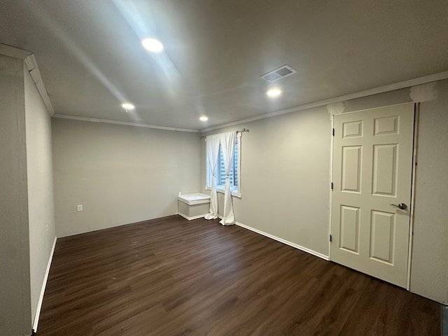 basement with dark hardwood / wood-style flooring and ornamental molding