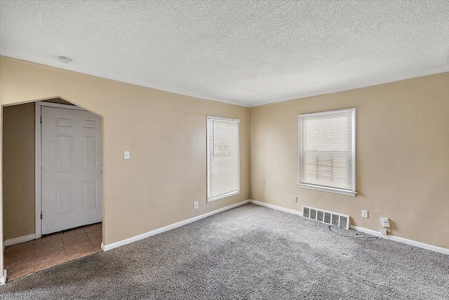 unfurnished room featuring carpet flooring and a textured ceiling