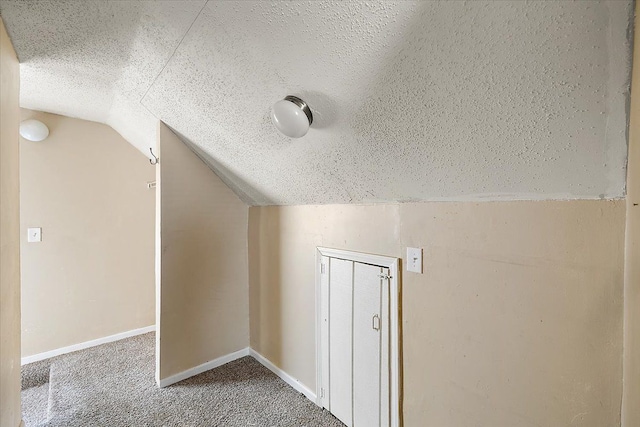 bonus room with carpet, lofted ceiling, and a textured ceiling