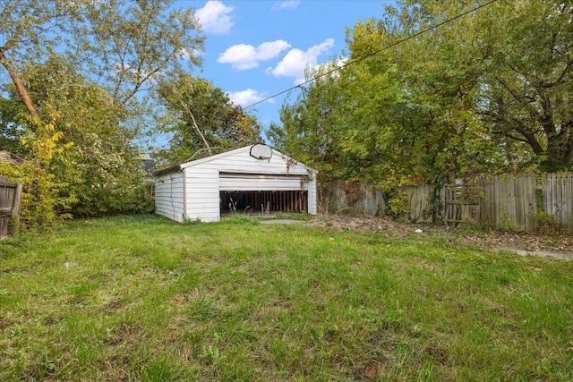 view of yard with a garage and an outbuilding