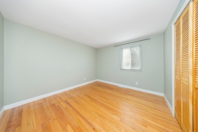 unfurnished bedroom featuring a closet and hardwood / wood-style floors