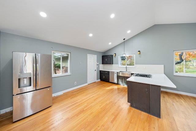 kitchen with kitchen peninsula, appliances with stainless steel finishes, light wood-type flooring, and vaulted ceiling